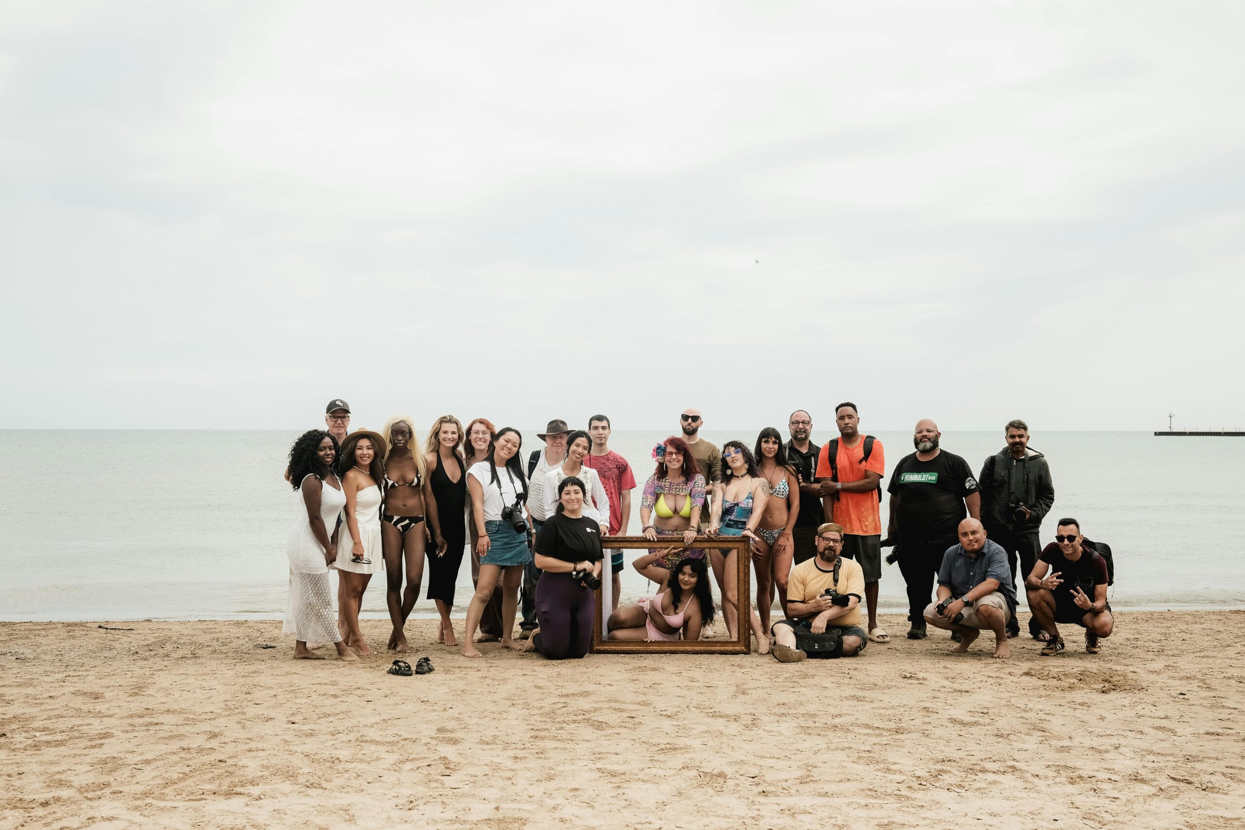 A diverse group enjoying a meetup on the sandy beach by the sea.
